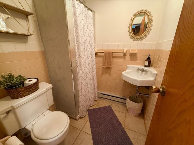 725 8th St NE, Staples, MN 56479 - full bathroom featuring tile walls, a baseboard heating unit, toilet, a sink, and wainscoting
