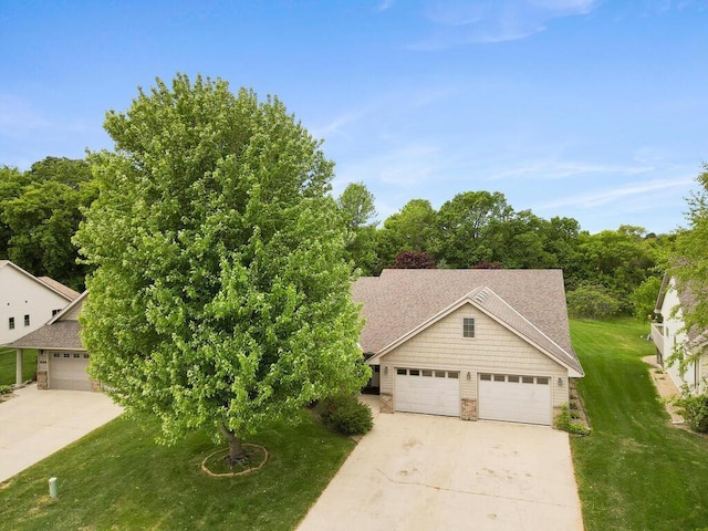 1232 Cypress Dr W, Annandale, MN 55302 - view of front of home with concrete driveway, a front lawn, stone siding, and a shingled roof
