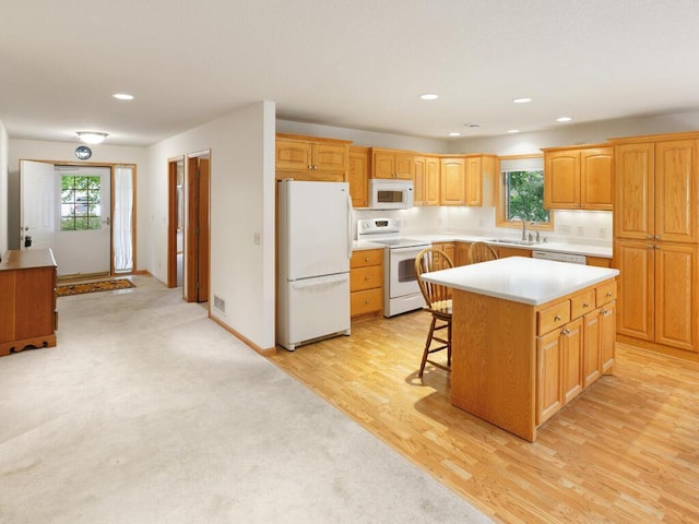 1232 Cypress Dr W, Annandale, MN 55302 - kitchen featuring white appliances, light countertops, a kitchen island, a kitchen bar, and a sink