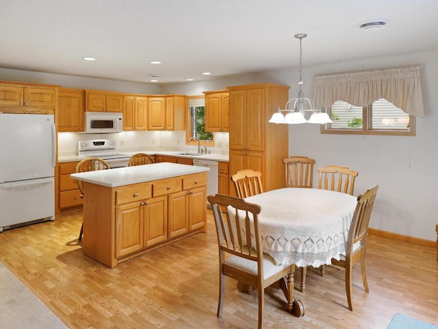 1232 Cypress Dr W, Annandale, MN 55302 - kitchen with white appliances, a sink, light countertops, a center island, and light wood-style floors