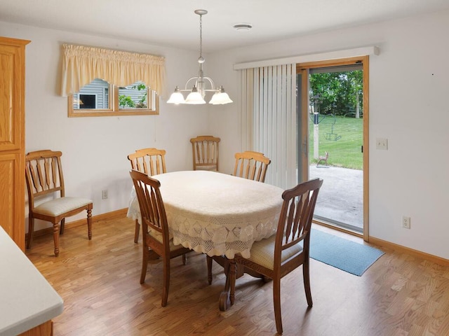 1232 Cypress Dr W, Annandale, MN 55302 - dining area featuring a chandelier, light wood-style floors, and baseboards