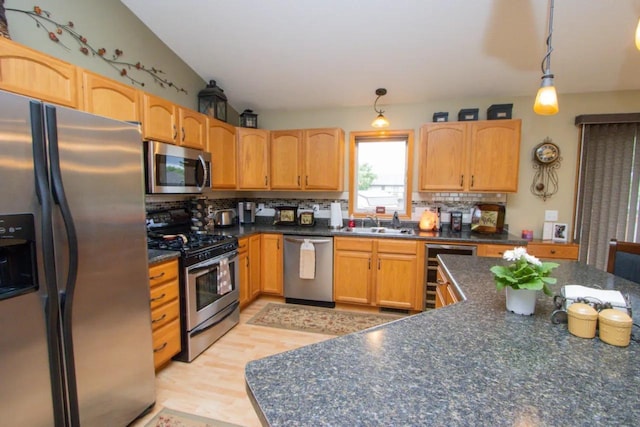 124 Waynesborough Way, Mankato, MN 56001 - kitchen featuring appliances with stainless steel finishes, dark countertops, a sink, backsplash, and beverage cooler