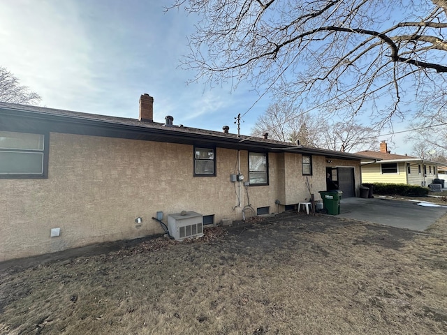 2814 Matilda St, Roseville, MN 55113 - back of property featuring an attached garage, stucco siding, a chimney, and driveway