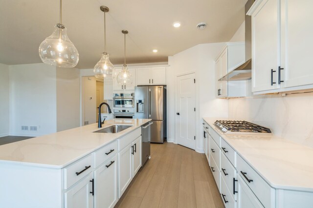 11454 Fieldstone Dr, Rogers, MN 55311 - kitchen with stainless steel appliances, a sink, white cabinetry, a center island with sink, and recessed lighting