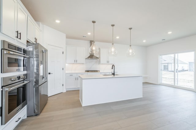 11454 Fieldstone Dr, Rogers, MN 55311 - kitchen with appliances with stainless steel finishes, wall chimney range hood, a sink, white cabinets, and light wood-style flooring