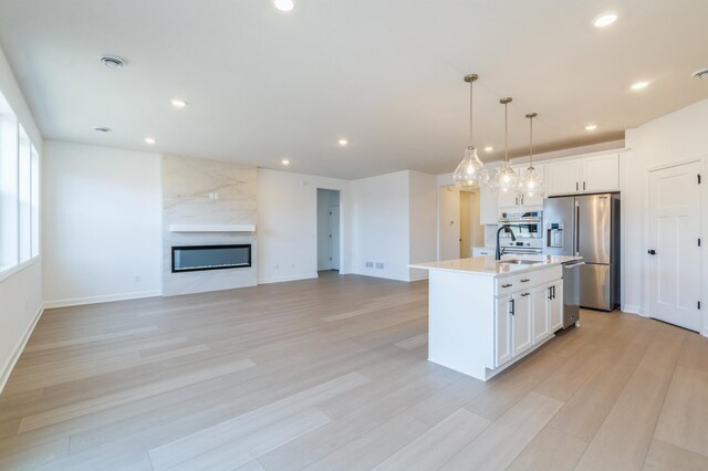 11454 Fieldstone Dr, Rogers, MN 55311 - kitchen featuring stainless steel appliances, recessed lighting, white cabinets, light wood-type flooring, and hanging light fixtures
