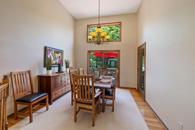 9378 Olympia Dr, Eden Prairie, MN 55347 - dining room featuring a towering ceiling, light wood-style flooring, and a chandelier