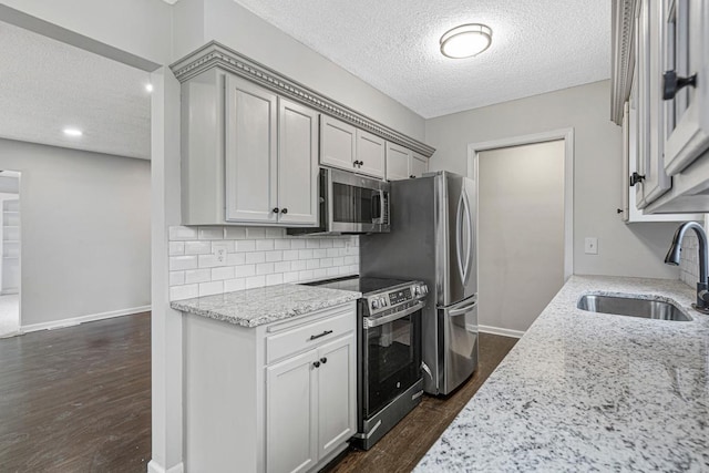 3633 Robinwood Ter, Minnetonka, MN 55305 - kitchen featuring stainless steel appliances, a textured ceiling, a sink, dark wood-style flooring, and light stone counters