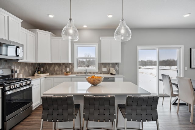 7581 Norway Ln, Lino Lakes, MN 55038 - kitchen with stainless steel appliances, a kitchen breakfast bar, light countertops, white cabinetry, and recessed lighting