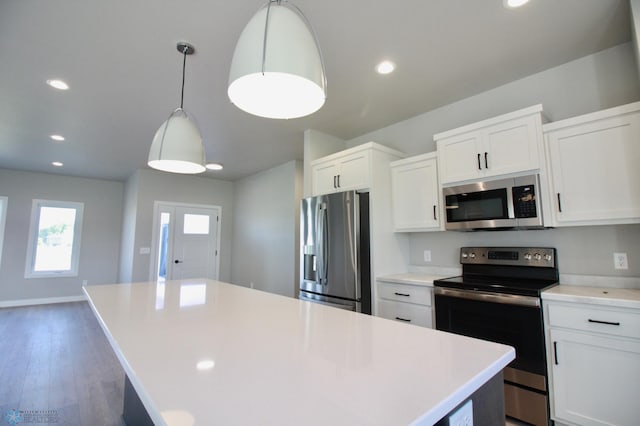 kitchen with stainless steel appliances, a kitchen island, white cabinets, light countertops, and recessed lighting