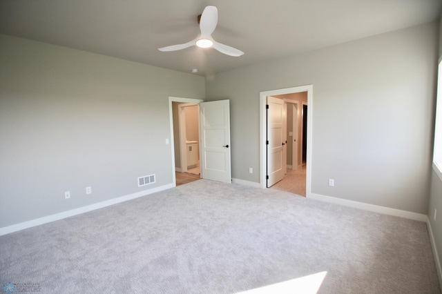 unfurnished bedroom with light colored carpet, baseboards, and a ceiling fan