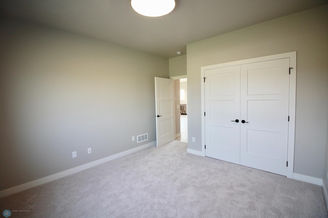 unfurnished bedroom featuring carpet, a closet, and baseboards