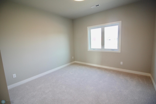 unfurnished room featuring light carpet and baseboards