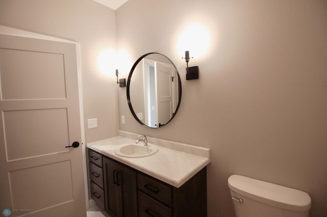 half bathroom featuring vanity and toilet