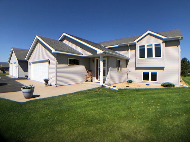 tri-level home with an attached garage, driveway, and a front lawn