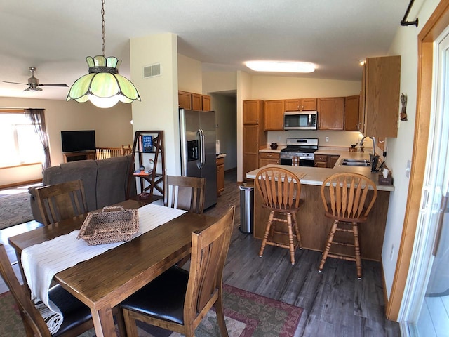 dining area featuring dark wood-style flooring, vaulted ceiling, and ceiling fan