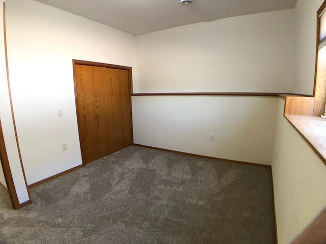unfurnished bedroom with carpet floors, a closet, and baseboards