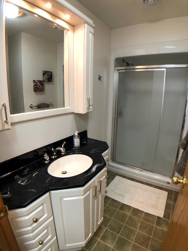 full bath with tile patterned flooring, a shower stall, and vanity
