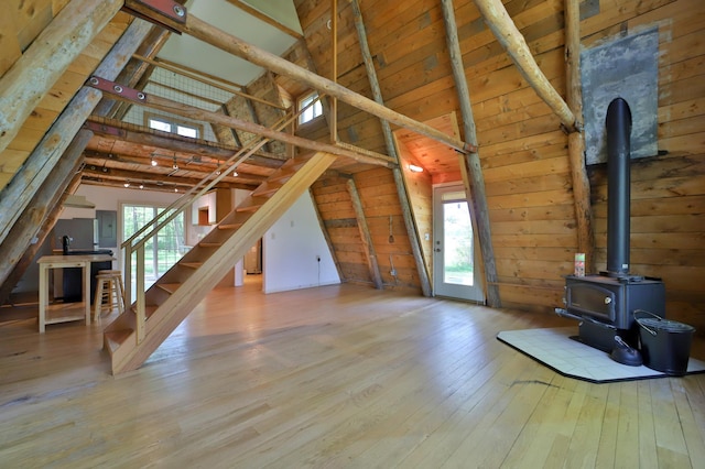 28435 392nd St, Browerville, MN 56438 - unfurnished living room featuring a wood stove, stairway, wood walls, wood-type flooring, and healthy amount of natural light