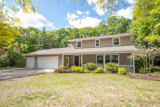 196 Mary Cir, North Mankato, MN 56003 - traditional-style home with an attached garage, concrete driveway, covered porch, a front yard, and stone siding