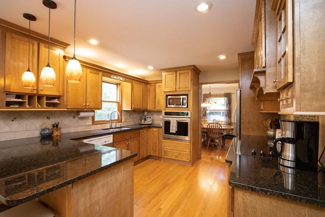 196 Mary Cir, North Mankato, MN 56003 - kitchen with appliances with stainless steel finishes, a sink, light wood finished floors, a peninsula, and brown cabinetry