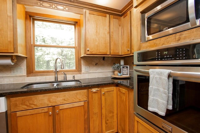 196 Mary Cir, North Mankato, MN 56003 - kitchen featuring appliances with stainless steel finishes, a sink, backsplash, and brown cabinets