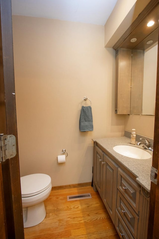 196 Mary Cir, North Mankato, MN 56003 - half bathroom featuring vanity, wood finished floors, toilet, and baseboards