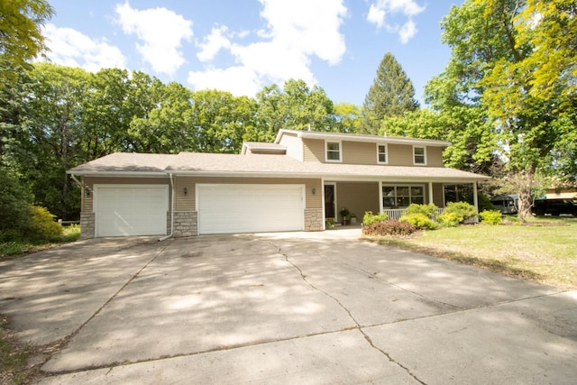 196 Mary Cir, North Mankato, MN 56003 - traditional-style house featuring a garage, covered porch, concrete driveway, stone siding, and a front lawn
