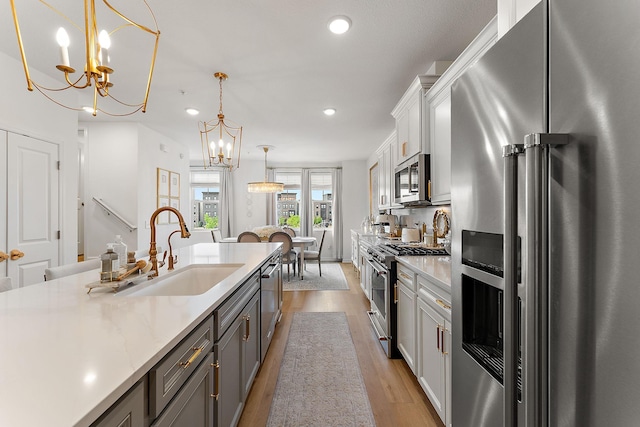 870 Mount Curve Blvd Unit F, Saint Paul, MN 55116 - kitchen featuring high quality appliances, a sink, a chandelier, light countertops, and recessed lighting