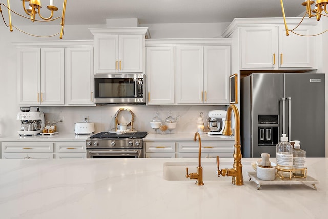 870 Mount Curve Blvd Unit F, Saint Paul, MN 55116 - kitchen with high end appliances, a chandelier, white cabinetry, decorative light fixtures, and light stone counters