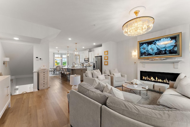 870 Mount Curve Blvd Unit F, Saint Paul, MN 55116 - living room with a chandelier, light wood-type flooring, a lit fireplace, recessed lighting, and baseboards