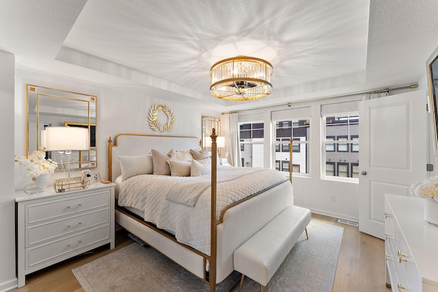 870 Mount Curve Blvd Unit F, Saint Paul, MN 55116 - bedroom with wood finished floors, a chandelier, and a textured ceiling