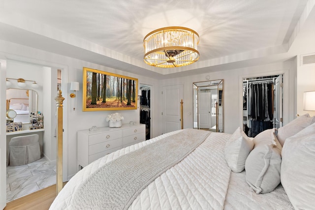 870 Mount Curve Blvd Unit F, Saint Paul, MN 55116 - bedroom with a spacious closet, a chandelier, a closet, and light marble finish floors