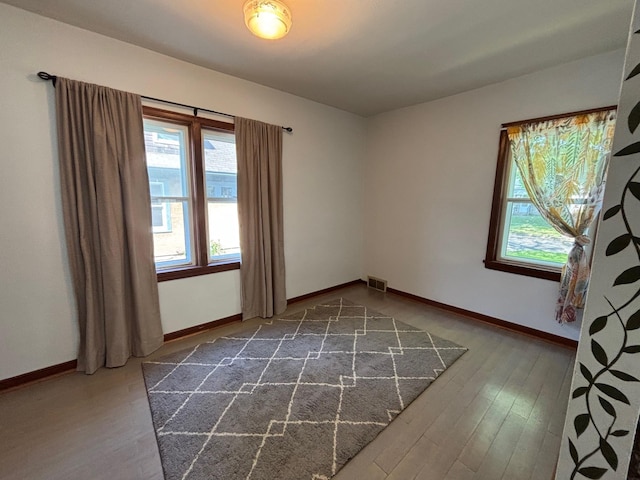 2428 14th Ave E, North Saint Paul, MN 55109 - spare room with healthy amount of natural light, baseboards, and dark wood-style flooring
