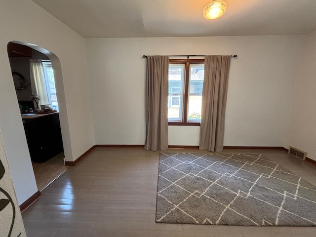 2428 14th Ave E, North Saint Paul, MN 55109 - unfurnished room with plenty of natural light, arched walkways, wood finished floors, and baseboards