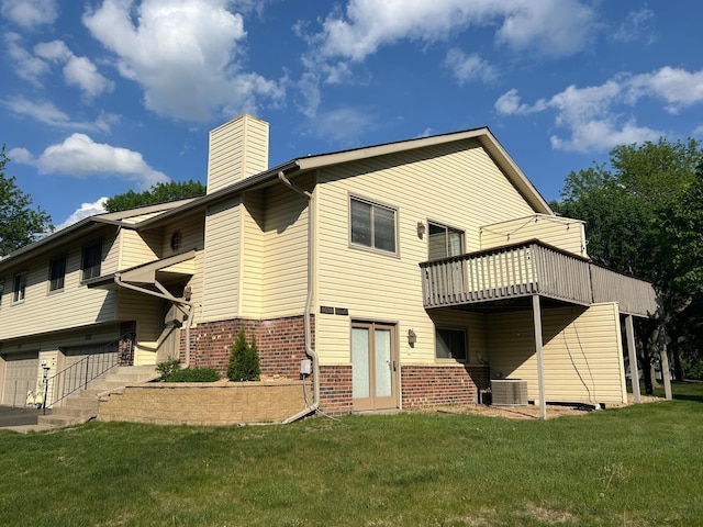 6640 Falstaff Rd, Woodbury, MN 55125 - back of house featuring a lawn, a chimney, brick siding, central air condition unit, and an attached garage