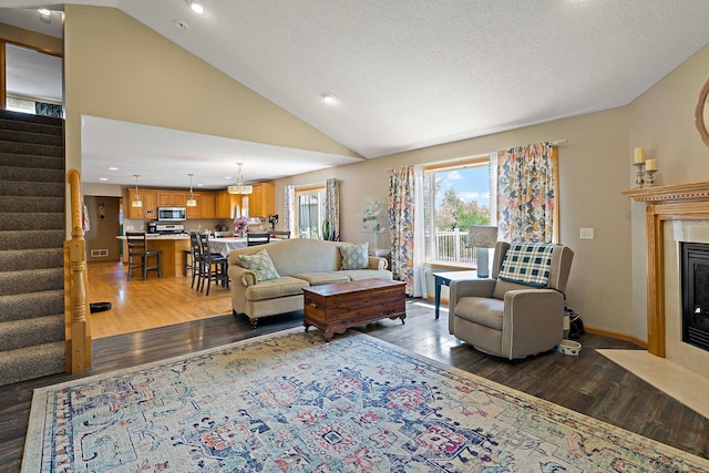 5901 106th Ave N, Brooklyn Park, MN 55443 - living room featuring wood finished floors, stairway, a fireplace with flush hearth, lofted ceiling, and recessed lighting