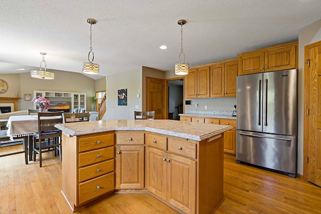 5901 106th Ave N, Brooklyn Park, MN 55443 - kitchen with high end refrigerator, a kitchen island, light wood finished floors, hanging light fixtures, and a textured ceiling