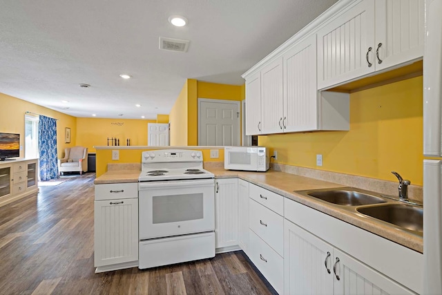 5901 106th Ave N, Brooklyn Park, MN 55443 - kitchen with white appliances, a peninsula, open floor plan, white cabinetry, and dark wood-style floors