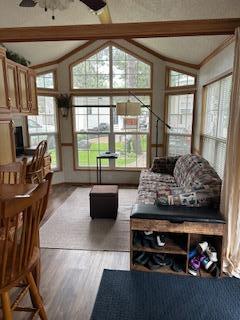 living area with wood finished floors and ceiling fan