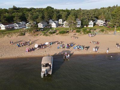 aerial overview of property's location with a large body of water and a heavily wooded area