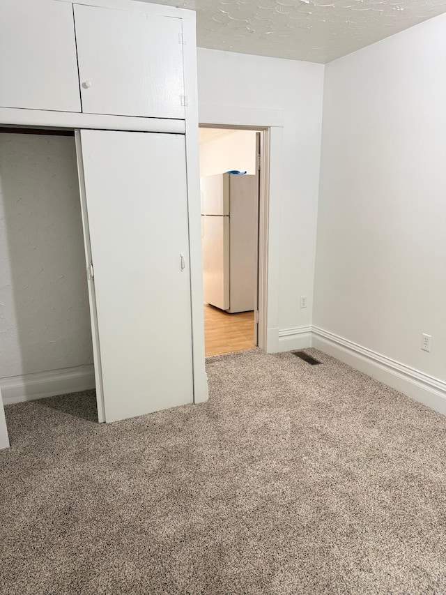 441 Minnesota Ave, Big Lake, MN 55309 - unfurnished bedroom featuring freestanding refrigerator, carpet, baseboards, and a closet
