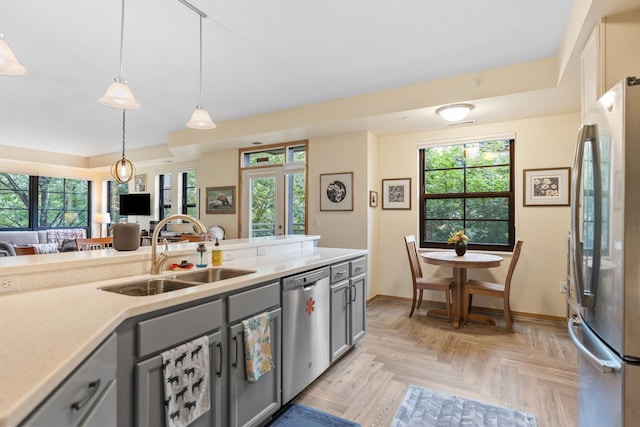 2565 Franklin Ave Unit 211, Saint Paul, MN 55114 - kitchen featuring stainless steel appliances, gray cabinets, light countertops, pendant lighting, and open floor plan