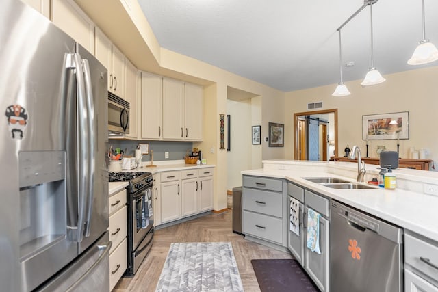2565 Franklin Ave Unit 211, Saint Paul, MN 55114 - kitchen with stainless steel appliances, light countertops, pendant lighting, and gray cabinets