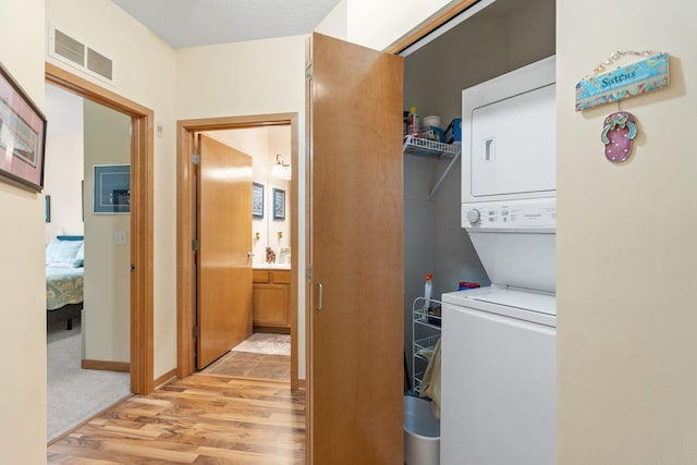 2565 Franklin Ave Unit 211, Saint Paul, MN 55114 - laundry area with stacked washing machine and dryer and light wood-style flooring
