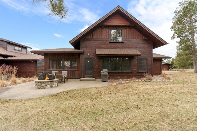 back of house with a fire pit, a patio area, and a lawn