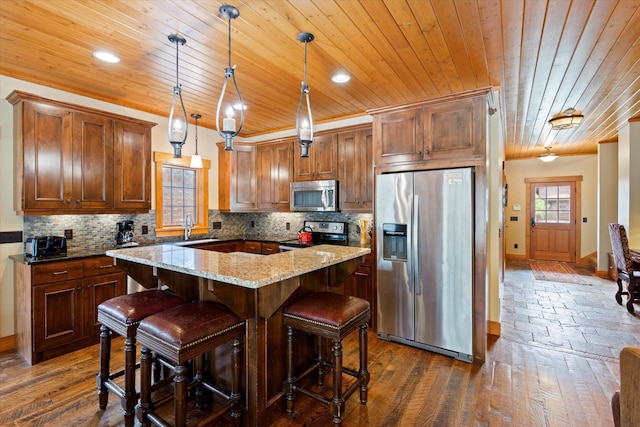 kitchen with appliances with stainless steel finishes, wood ceiling, baseboards, a sink, and a kitchen island