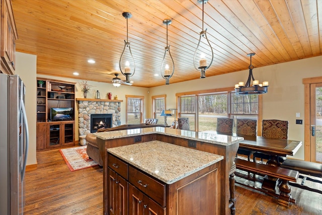kitchen featuring freestanding refrigerator, open floor plan, a center island, wooden ceiling, and dark wood-style flooring