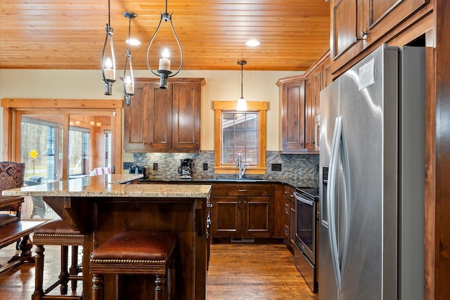 kitchen with appliances with stainless steel finishes, a sink, decorative backsplash, wooden ceiling, and a breakfast bar