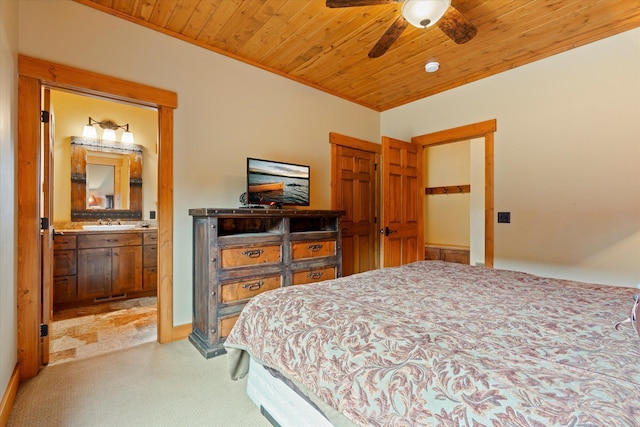 bedroom featuring light carpet, wood ceiling, a sink, and ensuite bathroom